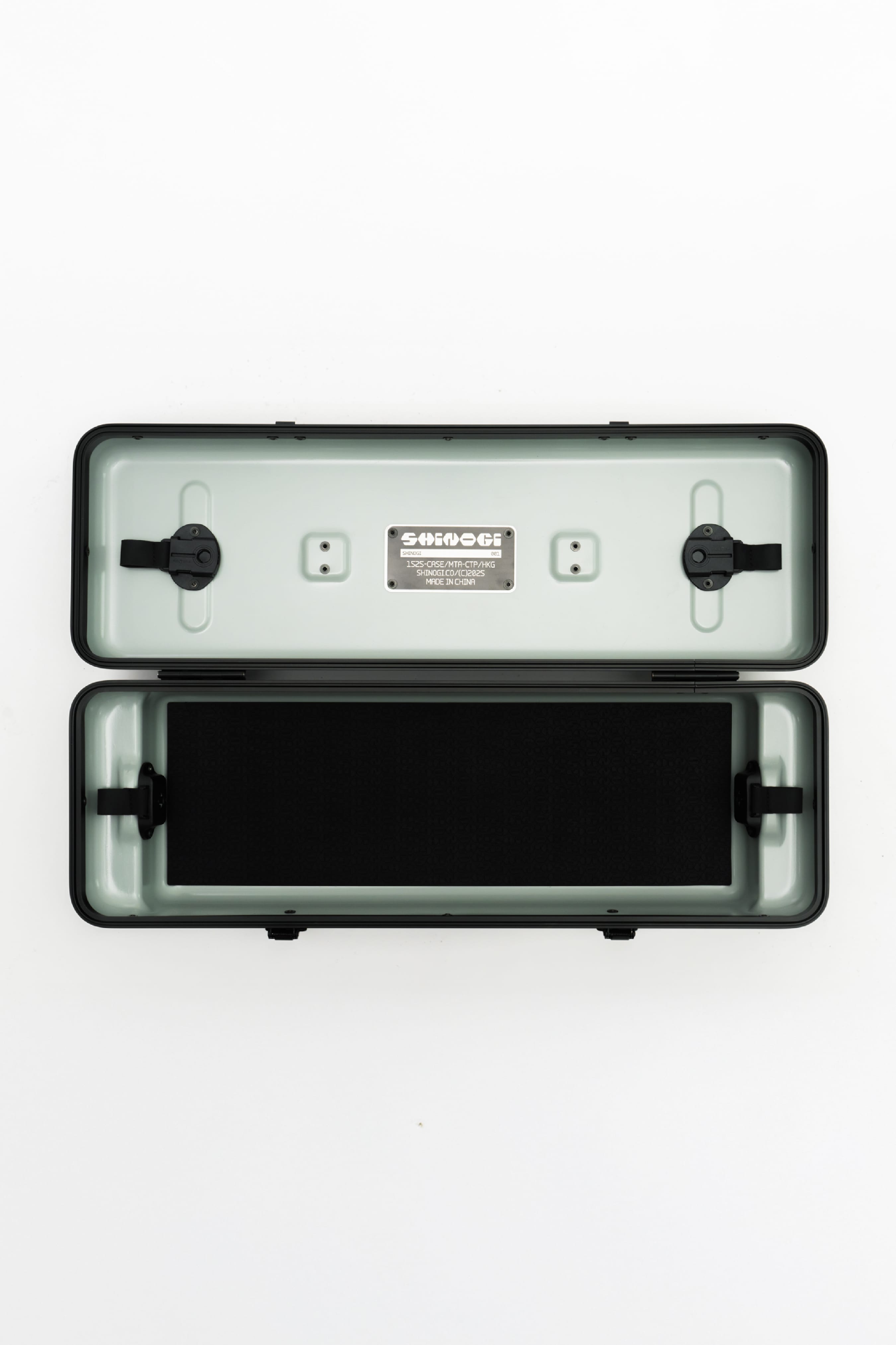 Shinogi Case 15-25 open interior showing sage green lining, stainless steel Shinogi nameplate, Fidlock magnetic closures, and black silicone mat insert