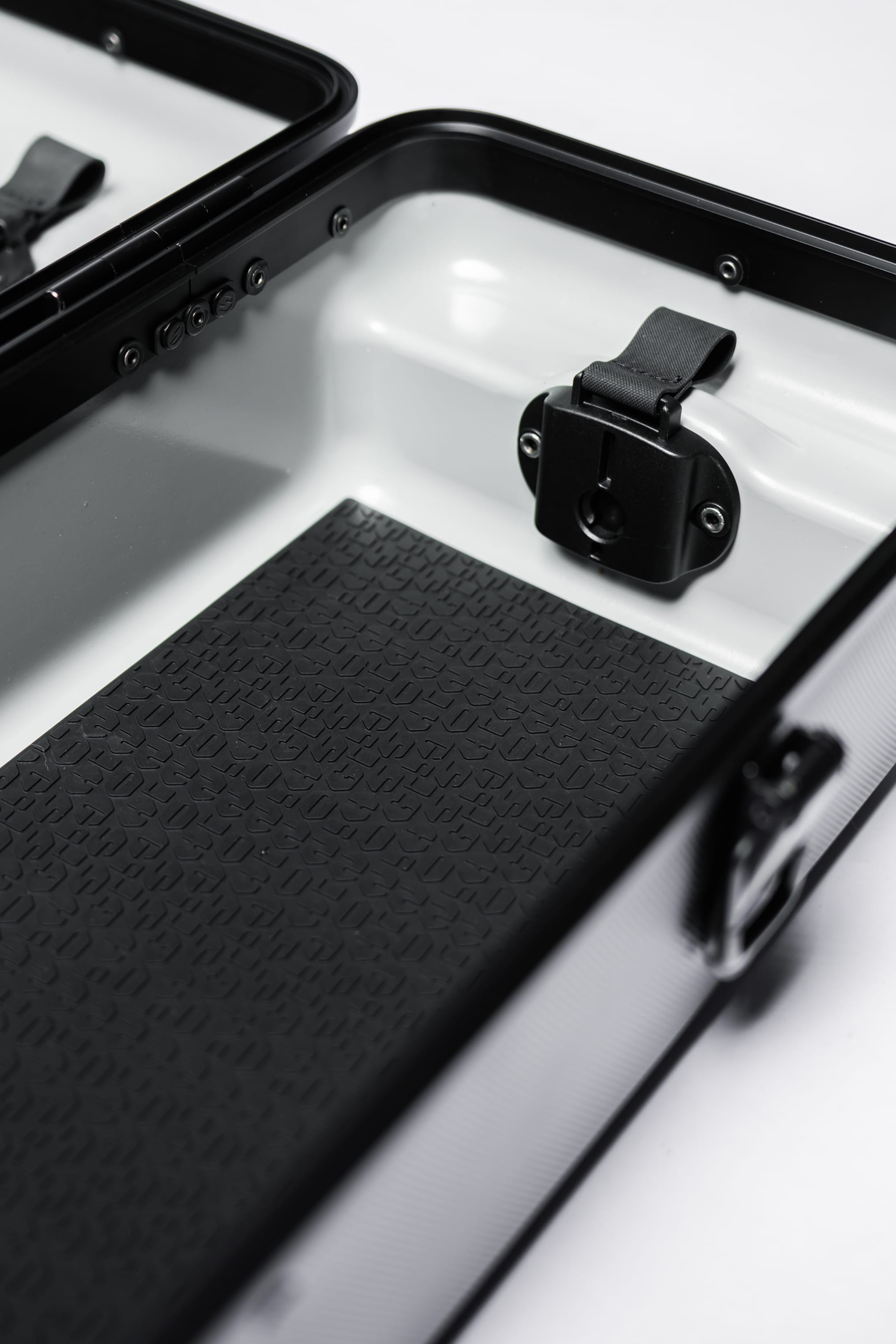 Shinogi Monogram Silicone Pad placed as a protective liner inside the open Case 15-25 knife case, showing fit alongside aluminum frame and Fidlock closure hardware